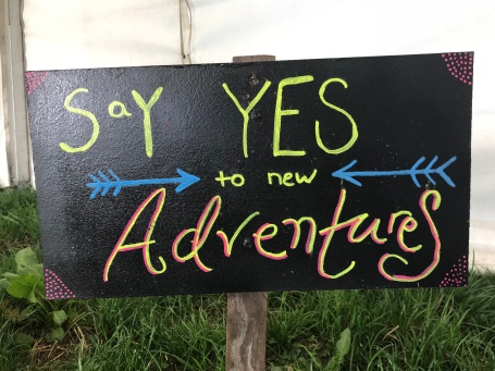 a chalk sign "say yes to new adventures"